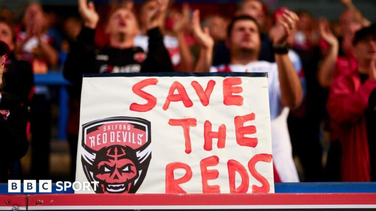Salford Red Devils: RFL give new side Championship membership A placard with "Save The Reds" and Salford Red Devils' club crest is displayed by their fans at a recent Super League game
