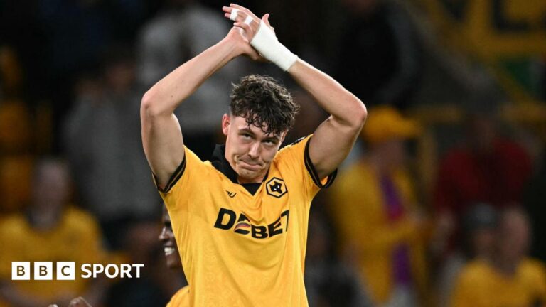 Jorgen Strand Larsen applauding with arms raised above his head while wearing Wolves match kit, with bandaging on his left wrist