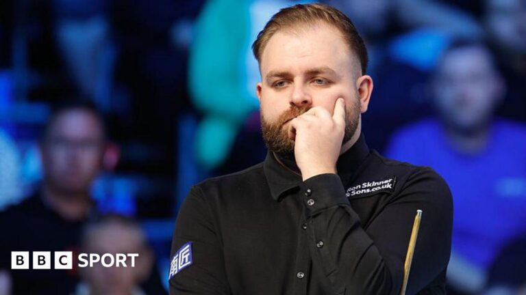 Welsh snooker player Jackson Page contemplates the table with hand to face