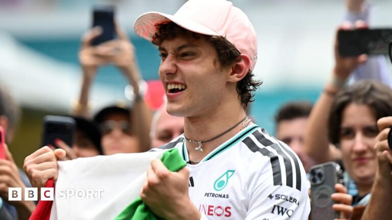 Miami Grand Prix: Kimi Antonelli steps up his level this season in dramatic fashion Kimi Antonelli celebrates his race win in Miami while holding the Italian flag. A crowd are gathered around him and taking photographs