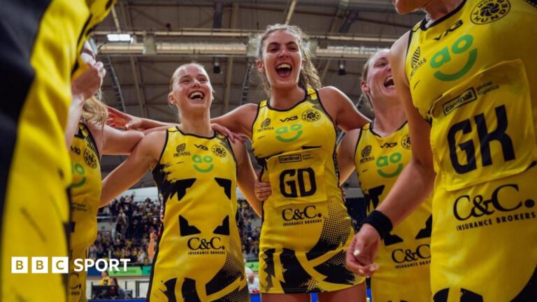 Manchester Thunder netball team in a celebratory huddle after a game.