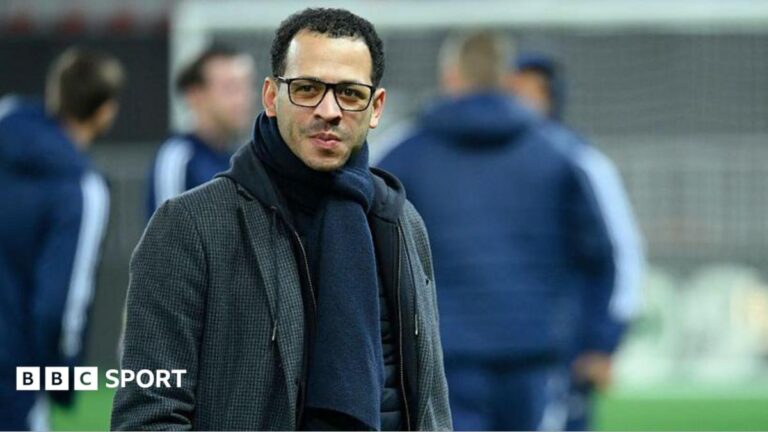 Liam Rosenior smiling and on the pitch while managing Strasbourg